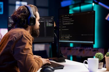 IT programmer listening music while fixing vulnerabilities in software enabling hackers to compromise operating system. Cybersecurity expert wearing headphones and using PC to patch security exposures clipart