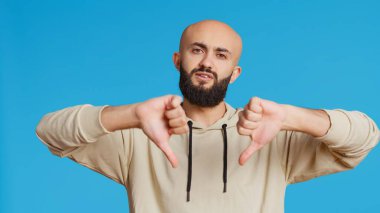 Ortadoğulu adam kamerada baş parmak işareti gösteriyor. Hoşnutsuzluk sembolü veriyor ve hayal kırıklığını sunuyor. Araplar stüdyodaki olumsuz jestlerden rahatsız olurlar. Kamera 2.