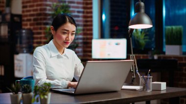 İş kadını, çizelgelerdeki satış istatistiklerini kullanarak gece geç saatlerde dizüstü bilgisayarında pazarlama projesi planlıyor. Ofis çalışanı mali kalkınma yaratmak için strateji araştırması yapıyor, kamera B