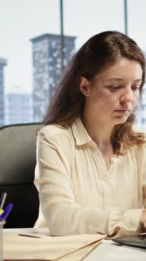 Modern bir şirkette çalışan, günlük işletmeleri yöneten, iş akışını optimize eden ve şirketin performans hedeflerine ulaşmasını sağlayan güçlü kadın CEO 'nun dikey videosu.