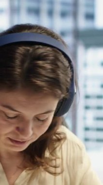 Dikey Video Dünyası girişimcisi kulaklığında müzik eşliğinde çalışmaktan ve kurumsal ofisindeki günlük görevleri çözmekten hoşlanıyor. Kararlı kadın CEO favori şarkılar ve verimlilikle eğleniyor