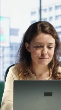 Vertical Video, en sevdiği şarkılara imza atarak kariyer geliştirme hedefleri üzerinde çalışırken aynı anda birden fazla iş yapan kendine güvenen iş adamını memnun etti. Genç bir kadın üst düzey bir ofiste müzikle eğleniyor.