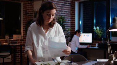 İşi bırakmaya karar verdikten sonra ofisten ayrılan üzgün bir çalışan, iş arkadaşına el sallıyor. Sinirli iş kadını, iş yerindeki son gece vardiyasından sonra masa eşyalarını paketliyor. Kamera A.