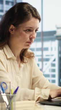 Modern bir şirkette çalışan, günlük işletmeleri yöneten, iş akışını optimize eden ve şirketin performans hedeflerine ulaşmasını sağlayan güçlü kadın CEO 'nun dikey videosu.