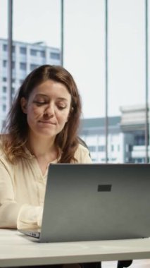 Vertical Video, en sevdiği şarkılara imza atarak kariyer geliştirme hedefleri üzerinde çalışırken aynı anda birden fazla iş yapan kendine güvenen iş adamını memnun etti. Genç bir kadın üst düzey bir ofiste müzikle eğleniyor.