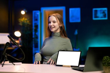 Neşeli genç şovmen giriş seviyesi düşük bütçe fiyat aralığında izleyiciler için tablet sunuyor. Gen Z medya yıldızı internet aboneleri önünde izole ekran taşınabilir aygıtını inceliyor