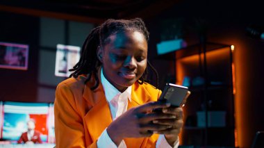 Üniversite öğrencisi ödevini laptopta yapıyor ve telefonda mesajlaşıyor, sosyal medya uygulamalarını kontrol etmek için okul tatilinin tadını çıkarıyor. Görev arayan ve akıllı telefon kullanan bir kız. Kamera B.