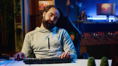 Oyun bağımlısı uyuşuk bir adam bütün gün online çok oyunculu oyunlarla uğraştıktan sonra kendini çok yorgun ve gerçeklikten kopuk hissediyor. Çok fazla video oyunu oynamaktan yorgun düşen uykulu bir adam.