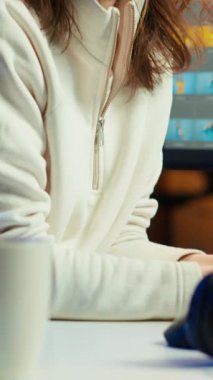 Mutlu fotoğraf editörünün dikey video portresi. Yaratıcı stüdyoda fotoğrafları düzeltiyor. Masadaki bir fincan kahvenin yanında. Neşeli fotoğrafçı editoryal içerik için en iyi resimleri seçiyor, kamera A