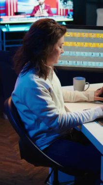 Medya ajansında çalışan dikey video fotoğraf editörü moda dergisi için profesyonel kamerayla çekilmiş editör resimleri seçiyor. Stüdyoda fotoğrafçı kahve içiyor, resim düzenliyor, kamera B