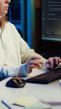 Yazılım işletim sistemindeki zayıflıkları düzeltirken müzik dinleyen dikey video bilişim programcısı. Siber güvenlik uzmanı kulaklık takıyor ve güvenlik açığını kapatmak için bilgisayar kullanıyor.