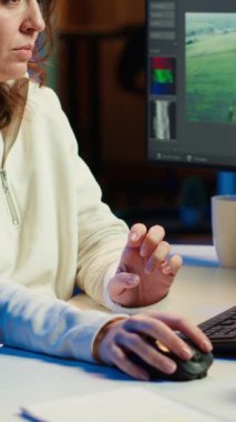 Yapım şirketi için çalışan dikey video editörü, müzik, diyalog, grafik ve efektleri ham görüntüler üzerine yerleştirmeden önce kamera galerisindeki görüntüleri kontrol ediyor, son proje için klip düzenliyor