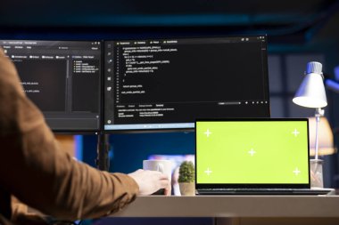 Şirket verilerini bozmaya çalışan siber suçluların trafiğini filtrelemek için yeşil ekran dizüstü bilgisayar kullanan bir yönetici. Krom anahtar defteri üzerinde çalışan bilişim uzmanı, kötü amaçlı yazılımı ve sahte saldırıları önlüyor