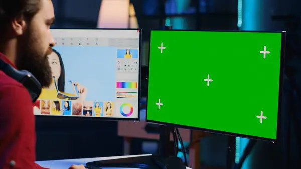 stock image Photo editor using green screen monitor to look at editorial pictures taken with professional camera for fashion magazine in photography studio. Freelancer browsing images on mockup PC in media agency