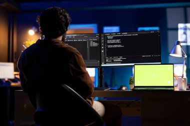 Programcı izole ekran dizüstü bilgisayar kullanarak yazılım uygulamaları tasarlıyor ve geliştiriyor. Model defter kullanılarak şirket sistemlerinin uygulanması ve sürdürülmesi