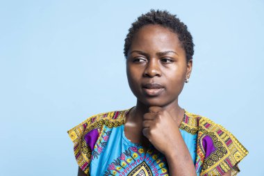 İçsel yüz ifadesi olan endişeli genç bayan, Afrikalı Amerikalı kadın kararsız ve yeni fikirler ya da sonuçlar üzerinde düşünüyor. Endişeli insan ciddi şeyler düşünüyor..