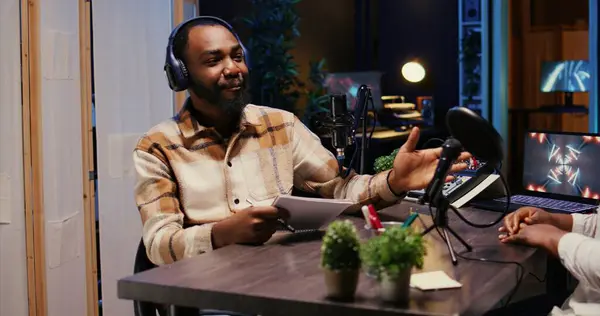 stock image Show host talking with guest in studio, listening to opinion on current events, filming video for social media. Influencer presenting woman to audience before starting podcast