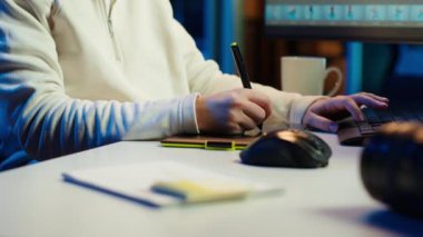 Fotoğraf editörü resim ışıklandırmasını düzenlemek için grafik tablet kullanıyor, görsel olarak çekici son ürünü dağıtıyor, podcastleri dinliyor. Freelancer ses kulaklığı takıyor, fotoğraflara bakıyor, kamera A