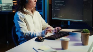 IT programcısı müzik dinlerken yazılım işletim sistemindeki zayıflıkları düzeltiyor. Siber güvenlik uzmanı kulaklık takıyor ve güvenlik açığını kapatmak için bilgisayar kullanıyor. Kamera A