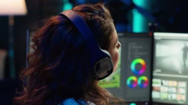 Freelancer çekimlere ses efektleri ekliyor, ev stüdyosunda çalışıyor. Yapım uzmanı, montaj uygulaması ve kamera A 'yı kullanarak ses kalitesini ölçmek ve geliştirmek için kulaklık kullanıyor.