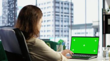 İşletme müdürü yeşil ekranla kendi ofisinde çalışıyor. Cihaz ekranına bakıyor ve yeni bir proje fikri geliştiriyor. Şirket kültürüyle güçlendirilmiş kadın girişimci. Kamera B.