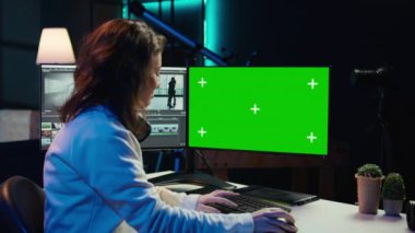 Freelancer dijital portföy görüntüleme videolarında izole ekran masaüstü bilgisayarı üzerinde çalışıyor. Video düzenleyici en iyi klipleri krom anahtar ekranında rötuş uygulaması kullanarak seçiyor, kamera B