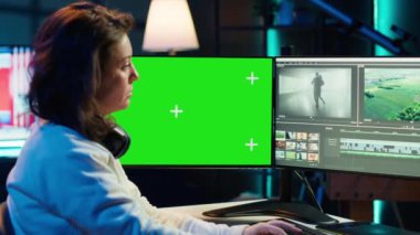 İzole ekran üzerindeki film montajını analiz eden video editörü, ofiste renk derecelendirme. Yapım stüdyosu çalışanı Chroma Key PC, kamera A 'da ham görüntülerle çalışıyor.
