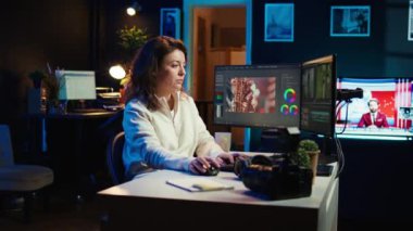 Video düzenleyici video montaj yaparken kullanılacak anahtar çerçeveleri seçiyor, bilgisayarla evden çalışıyor. Ofisteki film projesini düzenlemek için fareyi kullanan neşeli kadın, kamera B