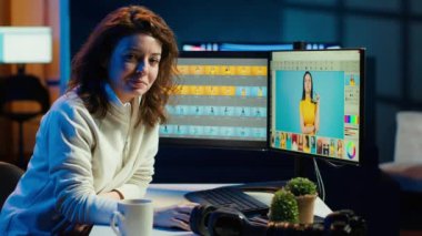 Neşeli fotoğrafçı bilgisayar ekranlarındaki görüntüleri düzenlemek için rötuş programını kullanıyor. Gülümseyen fotoğraf editörünün portresi yaratıcı stüdyo ofisinde renkli notlar veriyor, kamera A