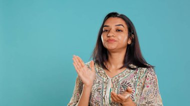 Kıskanç Hintli kadının portresi alaycı bir şekilde el çırpıyor, hayal kırıklığını gösteriyor, stüdyo arkaplanı. Kırgın küstah insan gözlerini devirir ve alaycı bir şekilde alkışlar, sinirli hisseder, kamera B