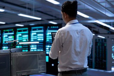 Sunucu merkezindeki donanım ve yazılım sorunları için tablet kullanan bir mühendis. Veri merkezinde sunucu ve ağ altyapısının uygulanması ve sürdürülmesi bilişim uzmanı