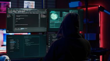 Güvenlik sistemlerini aşmaya çalışan deneyimli bir bilgisayar korsanı yeraltı sığınağında kod satırları yazıyor. Düzenbaz programcı aygıtları hackleyebilen betikler geliştiriyor, kamera A