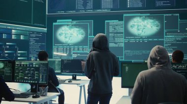 Yüksek teknoloji ofisindeki veri tabanına ve sunuculara erişemeyen hükümet hackerlarından oluşan hayal kırıklığına uğramış ekip melez savaş şifrelerini çalmak için büyük ekranla çalışıyor. Hüsrana uğramış uzmanlar. Kamera B.
