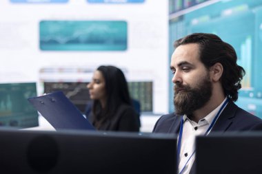 Yıllık üretkenlik raporlarını inceleyen profesyonel finans danışmanı, engelleri ve performans ölçümlerini bilgisayarda öğreniyor. İşletme uzmanı şirket başarısı için büyük veri bilgi grafiklerini inceliyor.