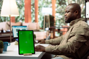 Küçük işletme sahibi, yıllık satış analizlerini başlangıç kârını artırmak için kullanarak yeşil ekranın yanında mali planlar üzerinde çalışıyor. Girişimci ev masasında bütçe dengesi analizi yapıyor.