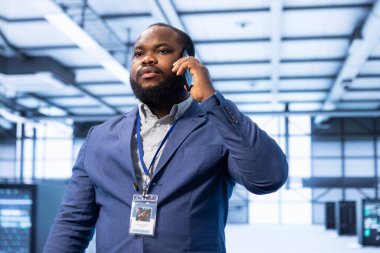 İleri teknoloji veri merkezindeki cep telefonunda gelişmiş bilgisayar donanımını tartışıyor. Telefon görüşmesi sırasında gelecekteki sunucu çiftliğinde profesyonel delege görevleri