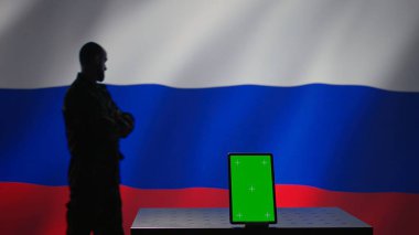 Mockup tablet used by Russian state security services to coordinate terrorism attacks. Green screen device used by ex KGB FSB agency to organize border expansion, isolated over Russia flag, camera B clipart