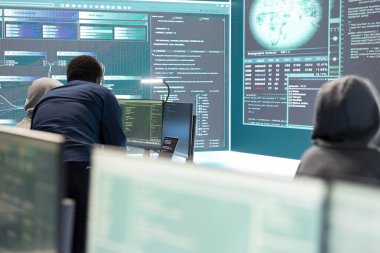 Siber istihbarat uzmanı, siber savunma ve siber saldırılara karşı korunma üzerine çalışan bir devlet kurumundaki büyük ekrandaki verileri inceliyor. Melez savaşında özel bilgi.