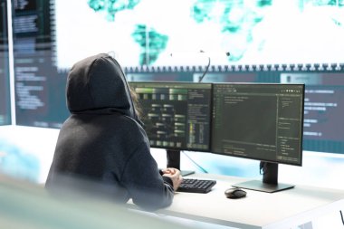 Siber istihbarat uzmanı, siber savunma ve siber saldırılara karşı korunma üzerine çalışan bir devlet kurumundaki büyük ekrandaki verileri inceliyor. Melez savaşında özel bilgi.