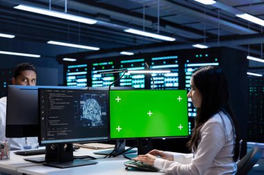 Yapay zeka yüklerinde kullanılan sunucu merkezindeki yeşil ekran bilgisayarda bakım yapan teknisyen ekibi. Ekip çalışanları sinirsel ağ veri merkezini model PC ile inceliyor