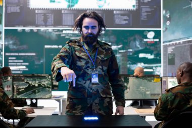 Askeri personel, bir hologramdaki küresel uydu kamera görüntülerini inceliyor. Bölgedeki piyade birliği askerlerini izliyor. Holografik projeksiyon kullanan eğitimli acemi..