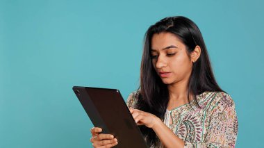 Gülümseyen kadın, alış veriş sitesine tablet kullanarak ödeme metodu ekliyor. Neşeli kişi dijital cihazdan kredi kartı, daktilo verisi, kamera B kullanarak satın alıyor.