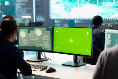 Siber güvenlik uzmanları bir devlet dairesinde şifreleme ve bilişim güvenliği kullanarak bir masaüstü bilgisayarının modelleme planı üzerinde çalışıyorlar. Rakip devlet sistemlerini hacklemek için siber operasyonlara odaklanılıyor.