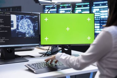 Yapay zeka yüklerinde kullanılan sunucu odasındaki yeşil ekran bilgisayarda kontrol yapan programcı. Krom anahtar PC ile sinirsel ağ veri merkezini denetleyen bilişim uzmanı