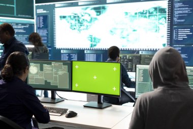 Hükümet hackerlarından oluşan bir ekip, yüksek teknoloji bürosundaki yeşil ekrana bakıyorlar. Siber savaş faaliyetleri için veritabanı sistemlerini hacklemek için birlikte çalışıyorlar. Yasadışı dolandırıcılık yapan uzmanlar.