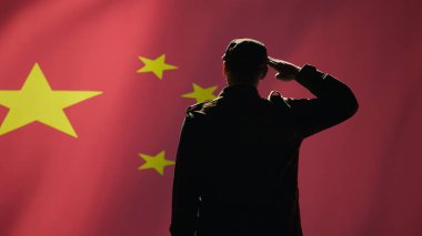 Member of chinese army doing saluting hand gesture towards China flag in command center, showing respect. Military unit in uniform serving Chinese Communist Party, doing honoring gesturing, camera B clipart