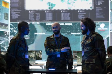 Kontrol odasında yeni görev saldırı planını tartışan çeşitli ekipler operasyon detaylarını gözden geçirmek için bir hologram projeksiyonu üzerinde çalışıyorlar. Askerler brifing için 3D holografi kullanıyorlar..