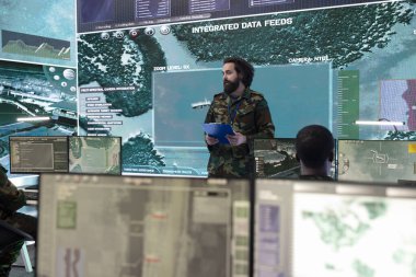 Special operations engineer examines a world map with gps tracking system on big screen, employing military high tech gear in monitoring room power base. Employs government satellite for missions. clipart