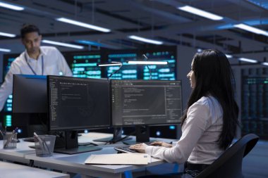 Bilgisayar kullanan yazılım geliştirici, veri merkezi performansını optimize ediyor. Kadın bilgisayarda kodlama, ana bilgisayarlarda sorun çıkarma, en iyi performansı sağlama ve izin süresini en aza indirme