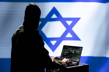 Anonymous Mossad military expert using laptop, operating anti ballistic system designed to counter missiles threatening country. Israeli intelligence operative in command room defends against rockets clipart